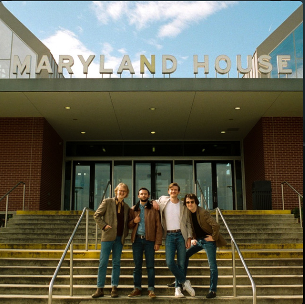 four men standing in front of a building